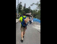 Guy carries brown dog in blue backpack 