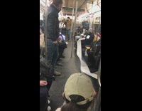 Person with sewing machine sewing large piece of fabric on subway