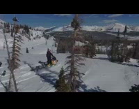 Guy rides snowmobile down mountain avalanche