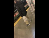 Guy waiting for subway bends legs 