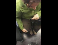 Woman green sweater flosses her teeth with floss on subway train