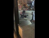 Guy poses for a picture with woman spreading legs wide on the street