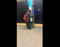 Guy hugs alarm button pillar in subway station