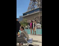 Two women in black and pink bikini poses by the pool