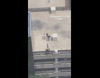 Two women poses on the rooftop building edge
