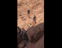 Blue hat black shirt girl brown rock 