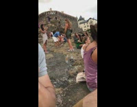 Green dress girl poses crowded rock seagull