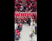 Students cheer on guy backflips on stage