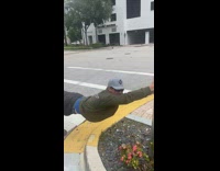 Guy holds onto sign pretends to be blown by wind 