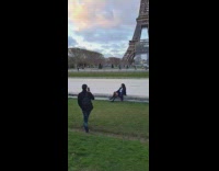 Woman with a baguette bread with the Eiffel Tower Behind