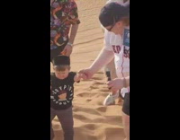 Guy picks up Hasbulla walks up desert sand dune