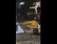 Man takes picture of woman that poses beside a luxury car