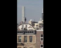 Two people jump rope outside on rooftop 