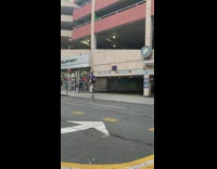Guy rides tall unicycle down street 