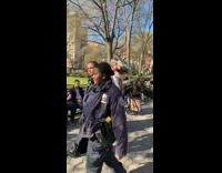 Man in colorful outfit and headpiece calls out NYPD police officers