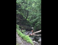 Girl sits on tree bridge river creek 