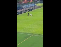 Woman Lays on Stadium Grass for Photos