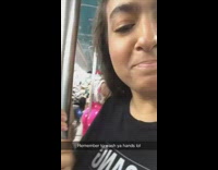 Person wearing pink pants leans against metal pole 