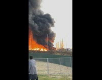 Man with small extinguisher walk to large fire