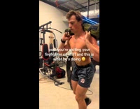 Man shirtless exercises inside the firehouse gym