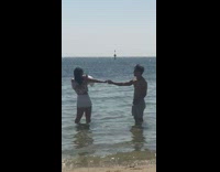 Girl holding guys hand in beach water picture