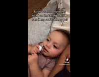 Baby boy sleeping next to mom with eyes open