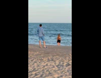 Woman black skirt dances at the beach