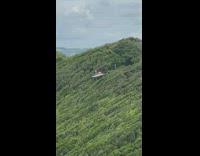 Two women bikini jump shot mountain cliff