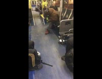 Man with green cup bends over on bus 
