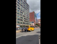 Men pushing cab on street