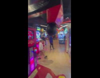 Woman plays a punch machine at the arcade