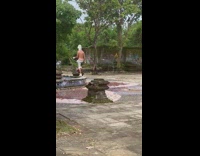 Man in white roman helmet shirtless on the fountain with drone