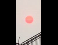 Guy zooms in on red sun smoke 