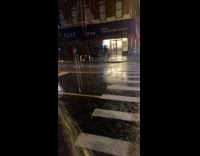 Man under black trash bag walking under rain