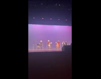 Dancers dressed as old people performing routine on stage 