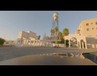 Girl flies drone outside building grass birds 
