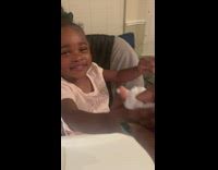 Little toddler girl in high chair making sad trombone sound 
