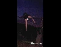 Barefoot girl climbs fence holding flashlight night 