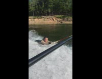 Woman holds onto handle on side of boat and rides over water with her feet