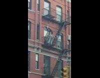 Woman in jeans poses on the apartment fire exit