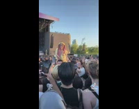 Two girls on shoulders at concert items thrown at them 