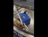 Flipped cooler on conveyer belt with food spilled