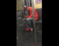 Guy in orange sits on train 