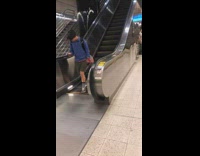 Guy on his cell phone walks on the wrong moving escalator and keeps walking in one place