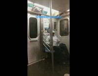Man in white beret plays air drums on lap with drum sticks on subway 