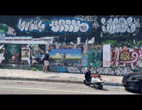 Guy wears helmet post art on wall