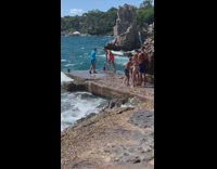 Guy red shorts balance on railings beach