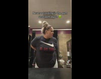 Woman puts on belt in gym bathroom