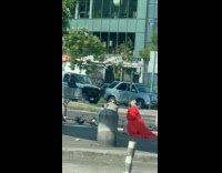 Woman in red coat recording sounds of pigeons