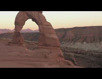 Long pink dress girl brown rock arch